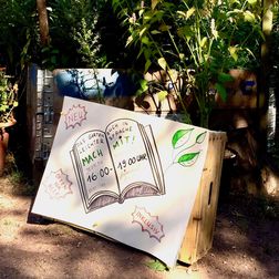 Foto von eine Zeichnung mit bunten Markern gemacht, die ein aufgeschlagenes Buch zeigt auf dem steht: Das Gartenbuch in leichter Sprache. Mach mit! Jeden Dienstag 16 bis 19 Uhr.
