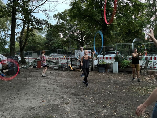 Verschienene Menschen werfen Hula-Hoops im himmelbeet